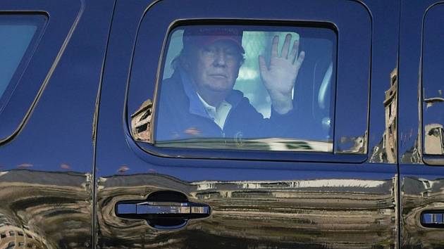 Americký prezident Donald Trump zdraví z limuzíny své příznivce.