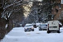 Automobil 13. ledna 2021 projíždí zasněženou ulicí na sídlišti Obeciny ve Zlíně