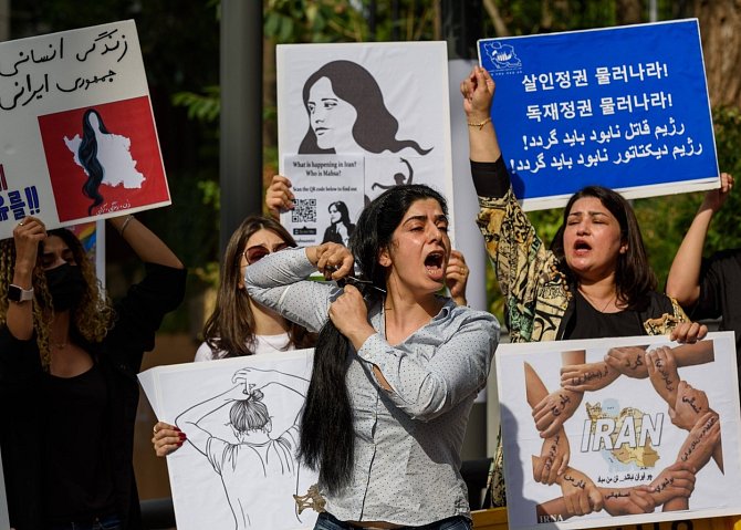 Íránská demonstrantka si stříhá vlasy na demonstraci kvůli smrti Mahsy Amíníové v jihokorejském Soulu. Ilustrační snímek