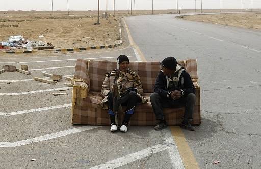 Povstalci  odpočívají  na gauči na kontrolním stanovišti v Ajdabiyahu, Libye, 15. března 2011