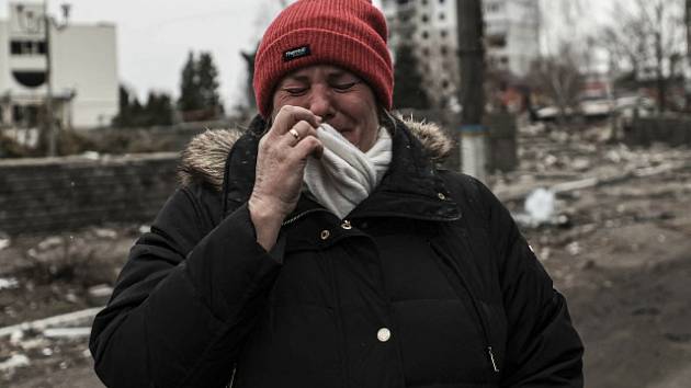 Plačící žena před zdevastovanou budovou v Boroďance.