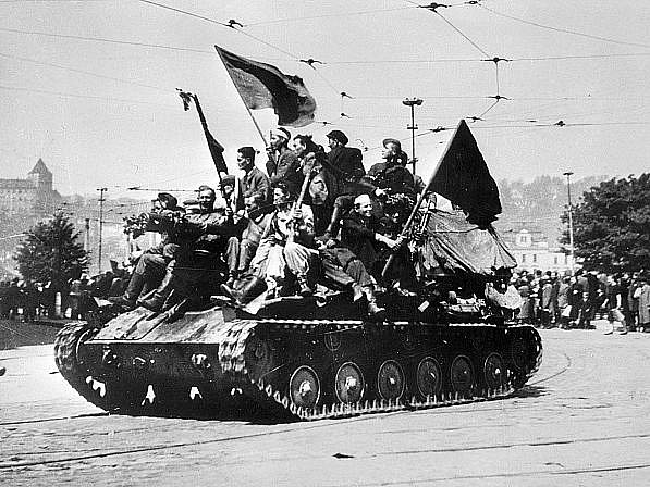 Příjezd Rudé armády do Prahy 9.května 1945. Na snímku: ruský tank, na kterém jedou vojáci i Pražané s prapory, projíždí kolem Mánesova mostu. 