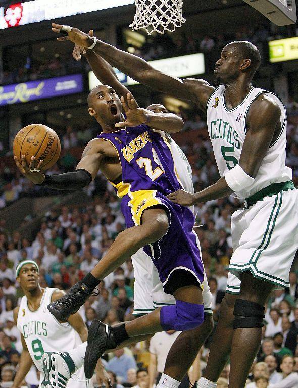 Kobe Briant z LA Lakers skóruje proti tvrdě bránícímu Kevinu Garnettovi z Bostonu.