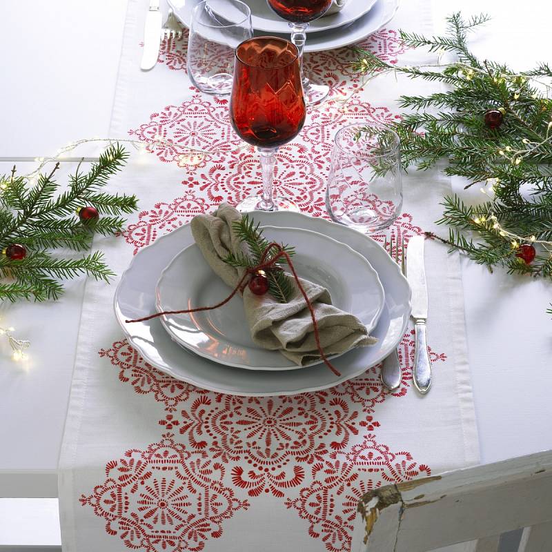 Různé způsoby výzdoby svátečního stolu v typických barvách Vánoc – červené sklenice, zelené jehličí.
