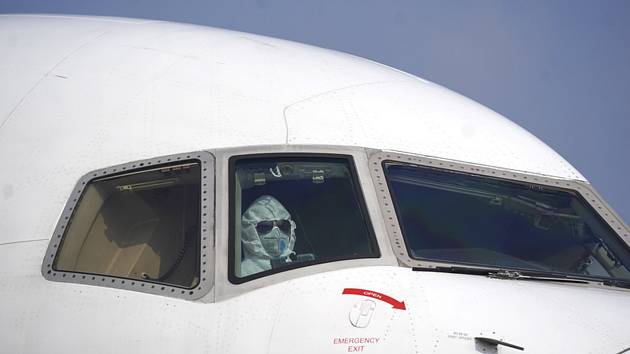 Pilot dopravního letadla v masce na mezinárodním letišti ve Wu-chanu 28. ledna 2020