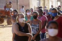 Lidé v rouškách z komunity Sol Nascente na okraji Brasílie