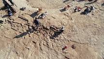 Archeologové a dělníci odkrývají zdi budov z hliněných cihel ve starověkém městě Kemune.