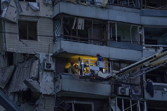 Záchranáři zasahují v troskách obytného domu v Dnipru na východě Ukrajiny 15. ledna 2023 po sobotním ruském raketovém útoku