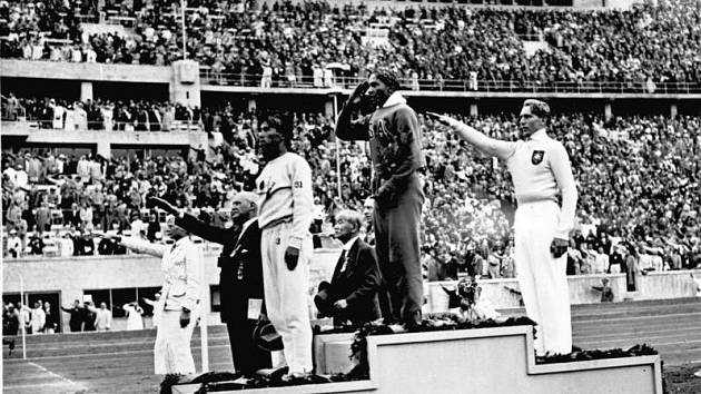 Jesse Owens na stupních vítězů po vítězství zlaté medaile ve skoku do dálky. Tím, že šlo o afroamerického sportovce, se Owens stal důvodem hněvu nacistického vůdce Adolfa Hitlera.