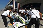 Mechanici pracují na monostu Brawn GP Jensona Buttona.