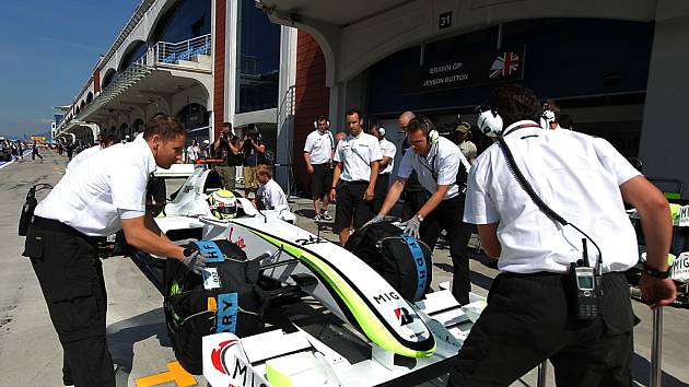 Mechanici pracují na monostu Brawn GP Jensona Buttona.