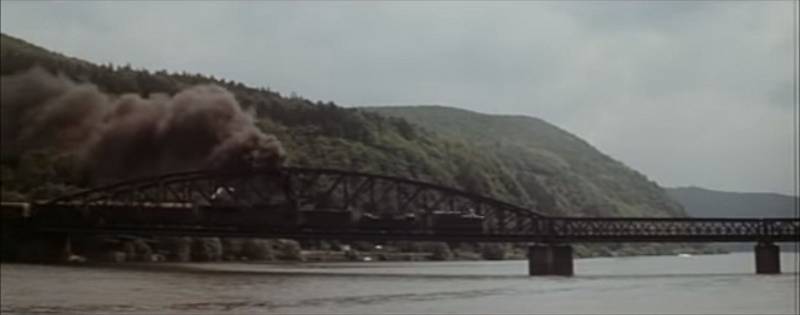 Měchenický most si v roce 1975 "zahrál" ještě ve filmu Zbraně pro Prahu, jehož úvodní scéna nápadně připomínala snímek Most u Remagenu