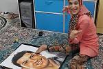 Handicapovaná Fatemeh maluje nohama portrét fotbalisty Cristiana Ronalda.