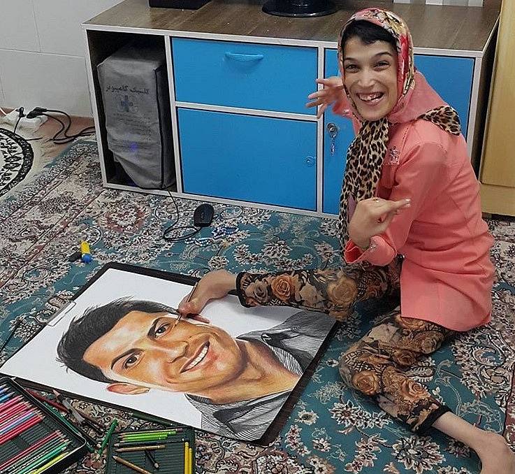 Handicapovaná Fatemeh maluje nohama portrét fotbalisty Cristiana Ronalda.