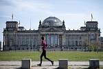 Běžkyně míjí budovu Říšského sněmu v Berlíně (na snímku z 11. dubna 2020)