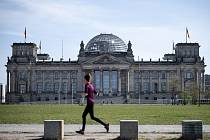 Běžkyně míjí budovu Říšského sněmu v Berlíně (na snímku z 11. dubna 2020)