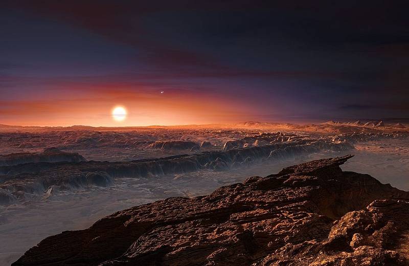 Umělecká představa povrchu exoplanety Proxima b, obíhající červeného trpaslíka Proxima Centauri, hvězdu nejbližší sluneční soustavě. Proxima b je o hmotnější než Země a nachází se v obyvatelné zóně své hvězdy, s teplotou vhodnou pro výskyt kapalné vody