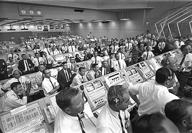 Členové Kennedyho vesmírného střediska vstávají krátce po startu Apolla 11 ze svých míst v řídícím centru letu