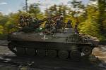 Ukrajinští vojáci na obrněném vozidle projíždějí vesnicí Šandrygolovo, která leží nedaleko města Lyman, 4. října 2022