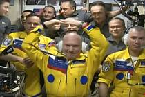 Na fotografii pořízené z videa Roskosmosu z 18. března 2022 jsou nově příchozí ruští kosmonauti na ISS ve žlutých oblecích Oleg Artěmjev (uprostřed), Denis Мatvejev (vpravo) a Sergej Korsakov