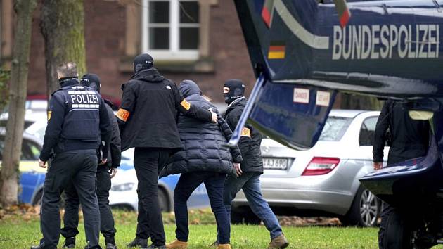 Policisté v německém Karlsruhe odvádějí podezřelého, kterého zatkli při zátahu proti krajně pravicovým extremistům, 7. prosince 2022