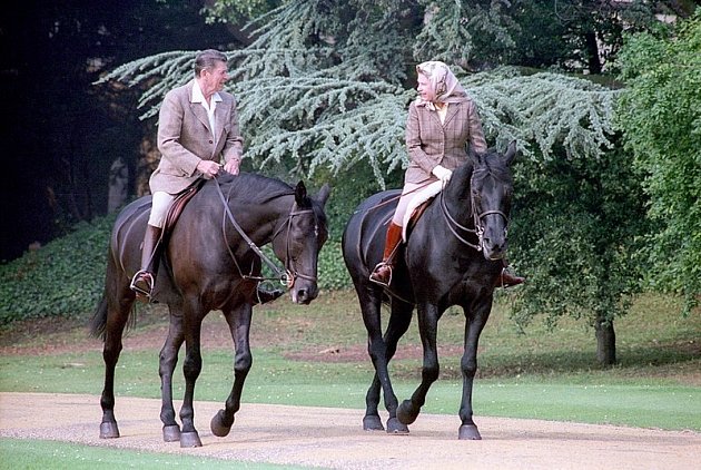 Královna Alžběta II. zbožňuje venkov a jízdu na koni. Stejně tak tvídová saka, jezdecké kalhoty a tartanový vzor. Na snímku s prezidentem Reaganem.