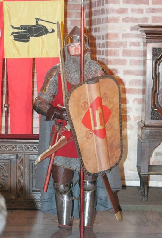 Litevský bojovník v kombinované zbroji, zahrnující prošívanici, plátovou ochranu nohou, nýtovanou kroužkovou košili a plátový kožený kabátec
