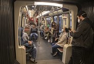 Lidé v rouškách cestují 24. dubna 2020 v pařížském metru