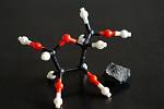 Model molekuly ribózy vedle meteoritu Murchison, sebraném v Austrálii, jenž je jednou ze dvou vesmírných hornin, kde se tento životně důležitý cukr našel