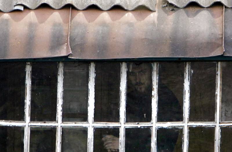Člen sekty se dívá oknem poté, co v podzemí strávil šest měsíců.