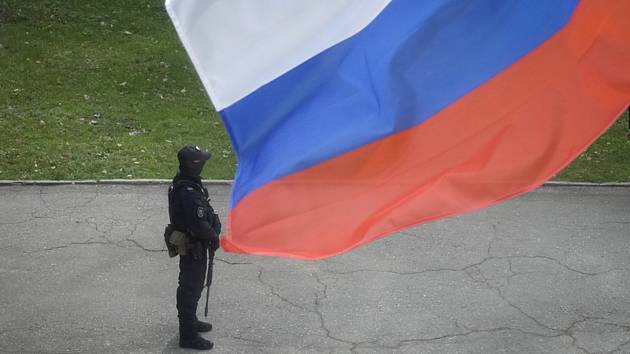 Ruský voják a ruská vlajka v Luhansku. Ilustrační foto.