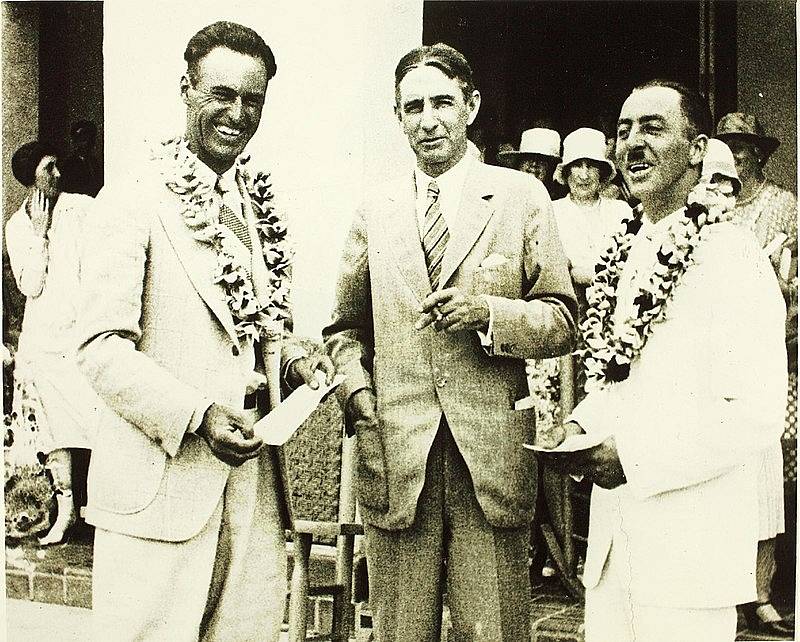 Boháč a iniciátor závodu James Dole (uprostřed) předává ceny dvěma pilotům, kteří zvládli doletět až na Havaj. První byl Arthur Goebel z Woolarocu (vlevo), druhý Martin Jensen z Alohy (vpravo).