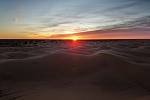 Východ slunce v poušti u kempu Zmela.
