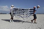 Pracovníci odklízejí lehátka z pláže v Miami Beach na Floridě před příchodem hurikánu Isaias