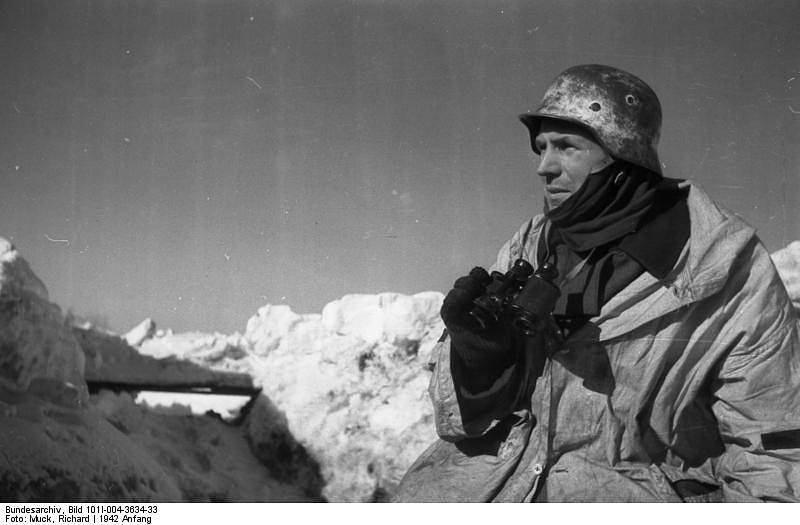 Německý voják v zimní výstroji a s dalekohledem