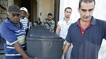 Muži nesoucí rakev z kostela během pohřbu na největším Havanském hřbitově