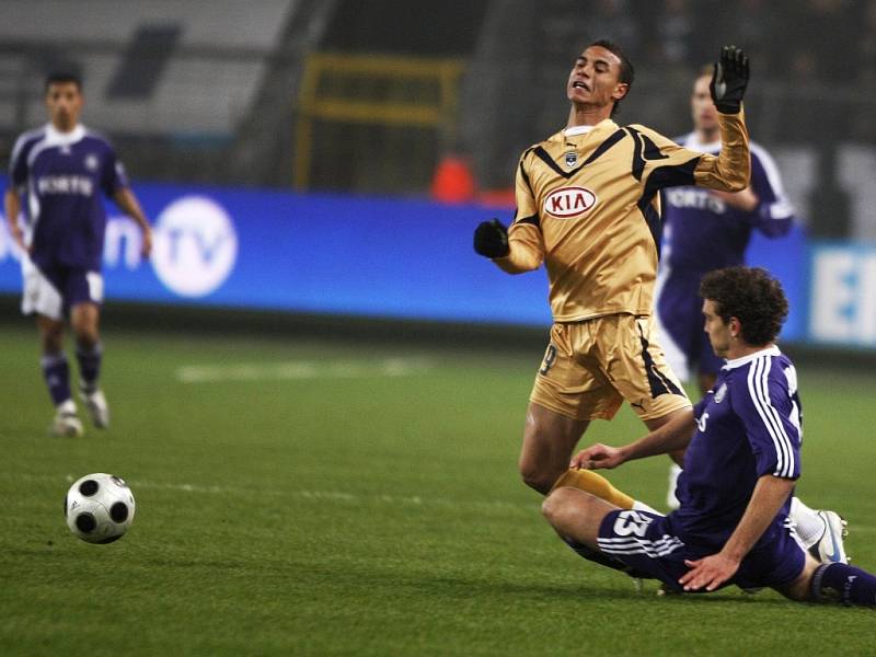 Marouane Chamakh z Bordeaux je atakován anderlechtským fotbalistou Rolandem Juhaszem. 