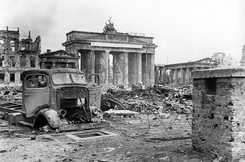 Berlín po svém pádu v květnu 1945. Na snímku vrak nákladního vozu na zničeném náměstí Pariser Platz, v pozadí poničená Braniborská brána