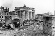 Berlín po svém pádu v květnu 1945. Na snímku vrak nákladního vozu na zničeném náměstí Pariser Platz, v pozadí poničená Braniborská brána. Ilustrační fotografie. 