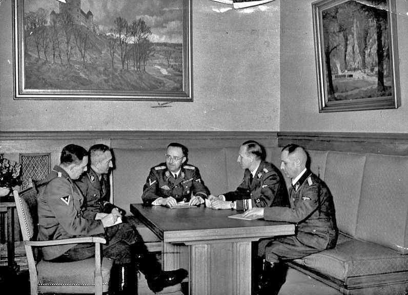 Schůzka činitelů německých zpravodajských a bezpečnostních služeb. Zleva  Franz Josef Huber, Arthur Nebe, Heinrich Himmler, Reinhard Heydrich a Heinrich Müller. Poslední dva jmenovaní se podobného jednání zúčastní ještě 18. května 1942 v Praze