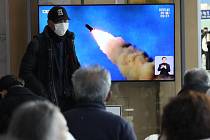 Na televizní obrazovce umístěné na vlakovém nádraží v jihokorejském Soulu běží reportáž o odpálení raket Severní koreou, 20. února 2023.