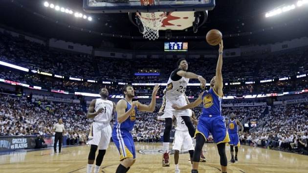 Stephen Curry a jeho střelecký pokus. Vše sleduje Anthony Davis z New Orleansu