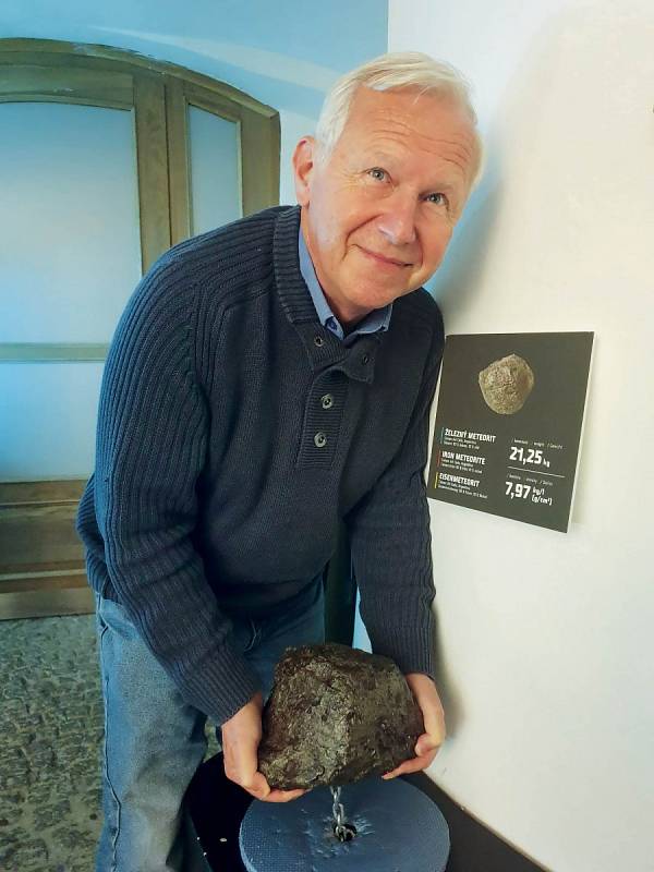 Milovník a znalec vltavínů Milan Prchal pózuje s meteoritem v Muzeu vltavínů v Českém Krumlově.