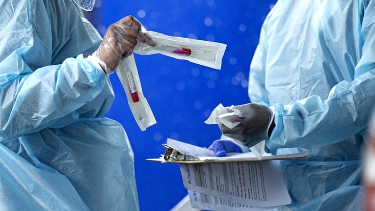 Zdravotníci se sadami pro odběr vzorků na koronavirus v testovacím centru v Miami v USA, 23. července 2020