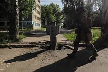 Ukrajinský voják prochází kolem nevybuchlé bomby v Severodoněcku