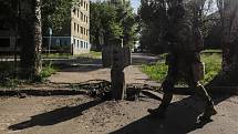 Ukrajinský voják prochází kolem nevybuchlé bomby v Severodoněcku