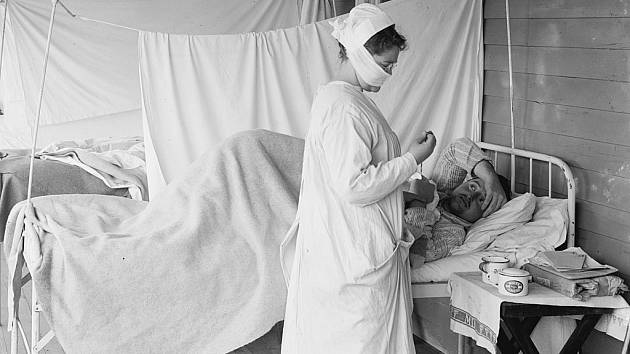 Sestra ošetřuje nemocného při epidemii španělské chřipky