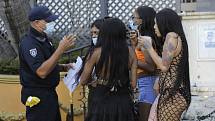 Policista mluví 24. července 2020 v Miami Beach s ženami o povinném nošení roušek.