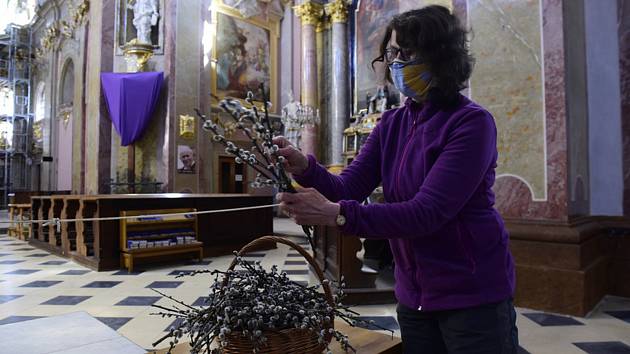 Žena si vybírá na Květnou neděli v bazilice Navštívení Panny Marie na Svatém Kopečku u Olomouce ratolesti posvěcených kočiček (na snímku z 5. dubna 2020)
