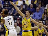 Klay Thompson (11) se snaží zablokovat střelecký pokus Paula George (13).